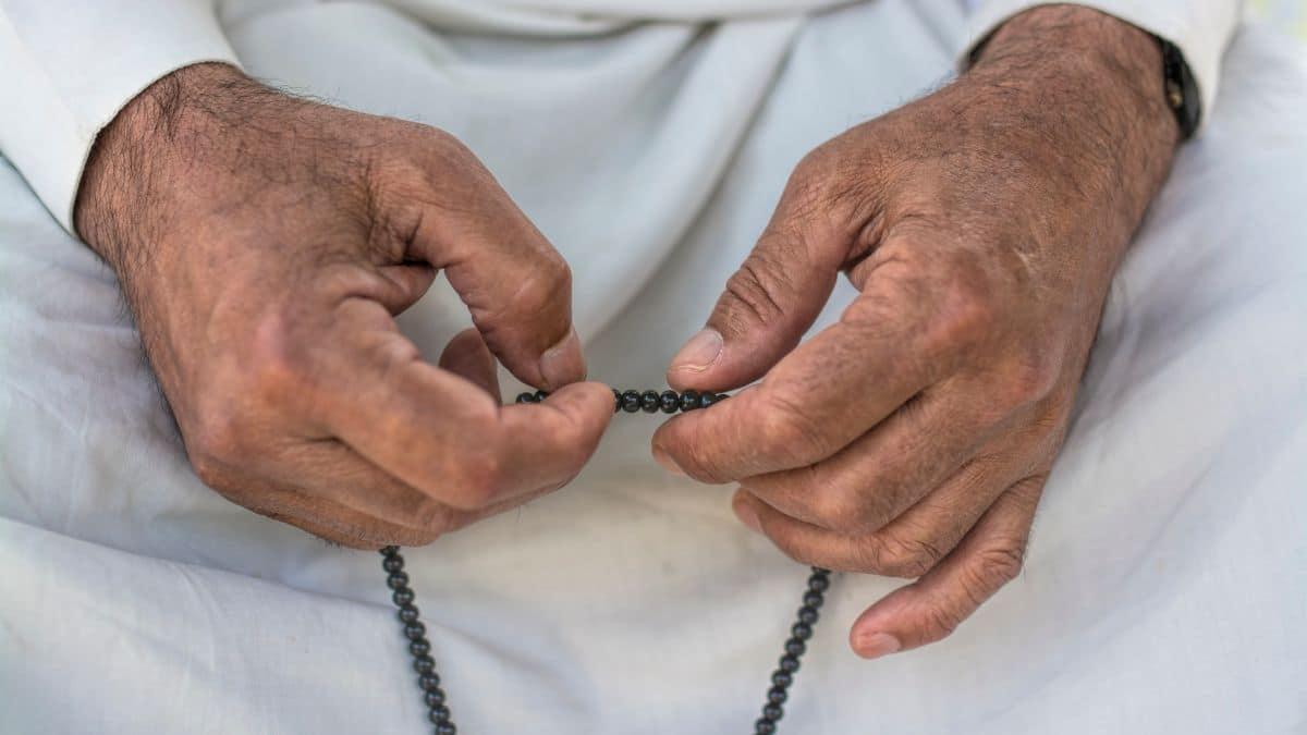 شخص يرفع يديه بالدعاء مع خلفية روحانية تعبر عن الاستغفار والسكينة