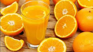 برتقالة مقطعة على طبق مع كوب ماء بجانبها، لتعزيز الهضم والنوم الهادئ