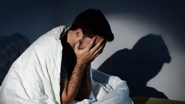 شخص يستريح في غرفة مظلمة مع أجواء هادئة، يرمز إلى نوم هادئ وصحي خلال رمضان.