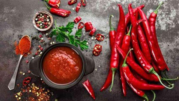 فلفل حار أحمر على سطح خشبي، يرمز إلى حرق الدهون وتحفيز الأيض.
