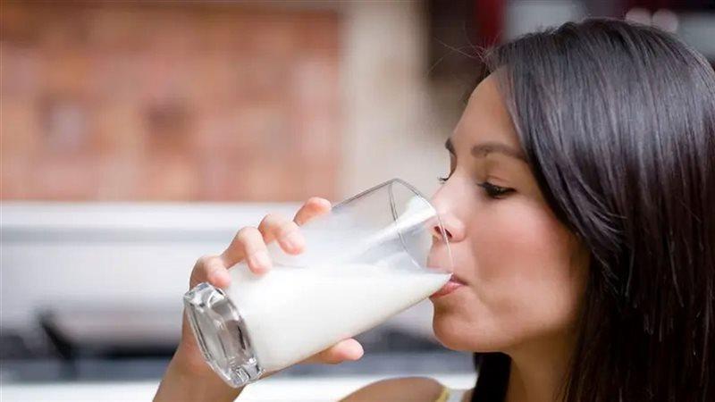 شخص مسن يشرب كوب حليب بعد أداء التمارين الرياضية لتعزيز قوة العظام