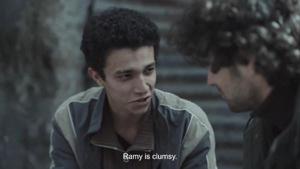 مشهد درامي من مسلسل صحاب الأرض يظهر عمار أمام الدبابات خلال رحلة هروبه مع أسرته وسط أجواء توتر وخوف