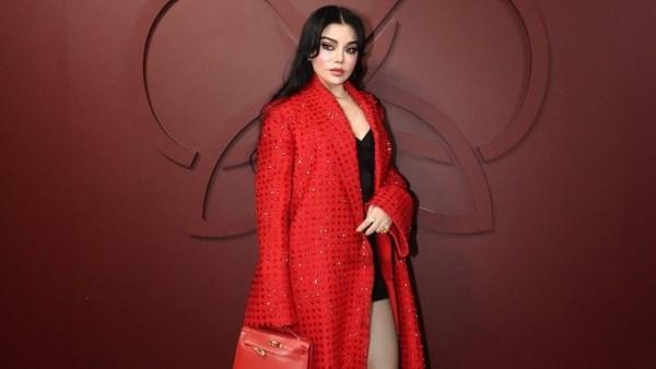 هيفاء وهبي بإطلالة حمراء جريئة في باريس خلال حضور عرض أزياء طوني ورد، تظهر بالفستان القصير والبلطو الأحمر وسط أجواء أنيقة.