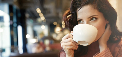 فنجان قهوة على طاولة مع نصائح لتجنب الغثيان