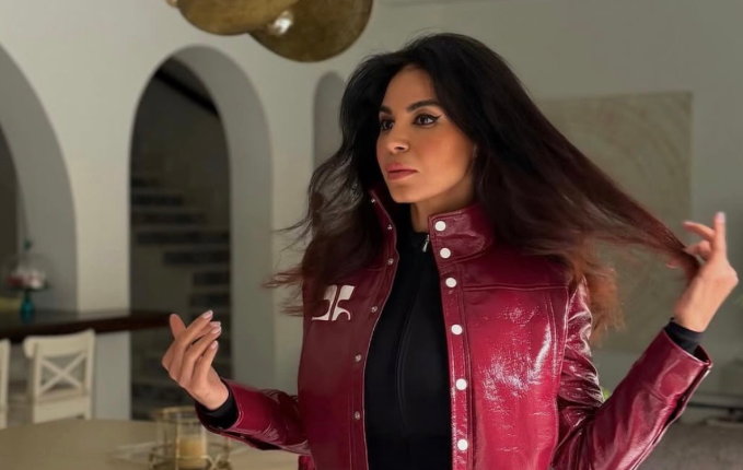 نسرين أمين ترتدي جمبسوت أسود طويل مع جاكت جلد نبيتي وبوت أسود