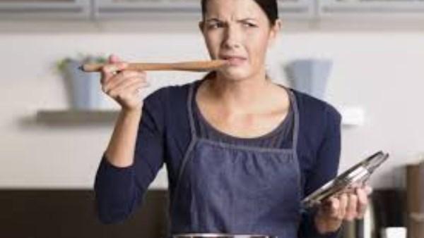 طاهٍ منزلي يتذوق الطعام أثناء الطهي لتعديل النكهة