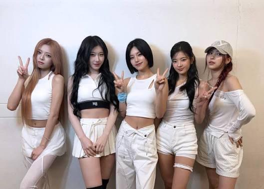 فرقة ITZY خلال عرض فني مع إضاءة مسرحية مميزة