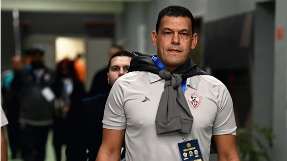 عبد الواحد السيد مع شعار نادي الزمالك.