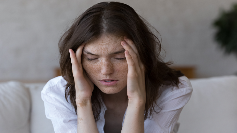 رجل يمسك رأسه بسبب صداع بعد يوم طويل من العمل