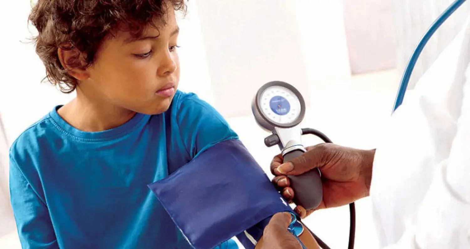 طفل أثناء قياس ضغط الدم في زيارة طبية دورية
