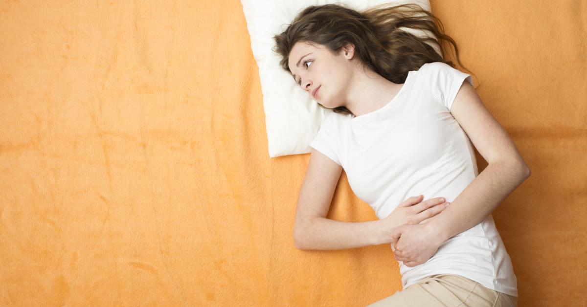 امرأة تمسك بطنها معبرة عن ألم الدورة الشهرية