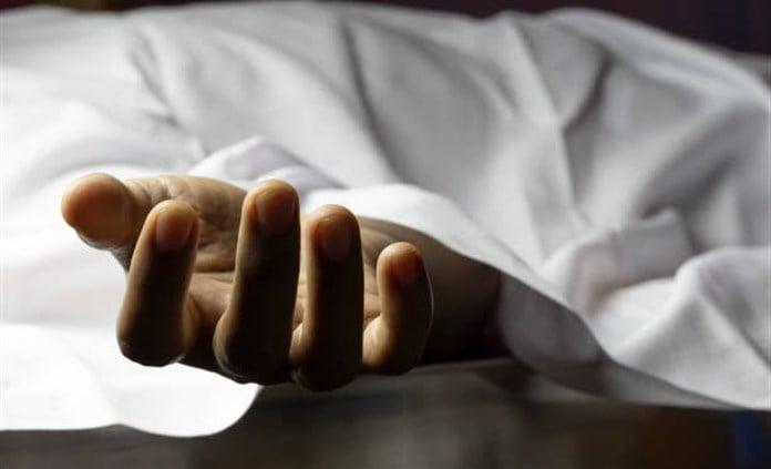 رجل مسن يرفع يديه بالدعاء بينما يتسلل نور الغروب من نافذة
