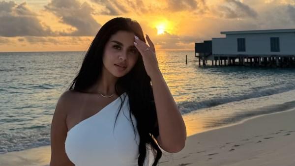 منة عرفة بإطلالة صيفية باللون الأبيض من جزر المالديف أمام البحر وقت الغروب